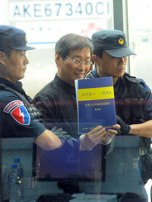 張安樂6月底抵達臺灣后手持“和平統(tǒng)一、一國兩制”的手冊。