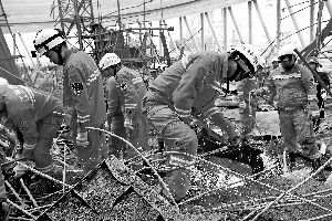 11月24日,救援人員在事故現場進行搜救。新華社發