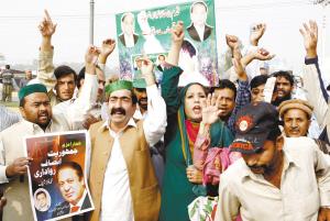 25日,謝里夫的支持者高舉他的海報,在拉合爾機場外等待他的歸來